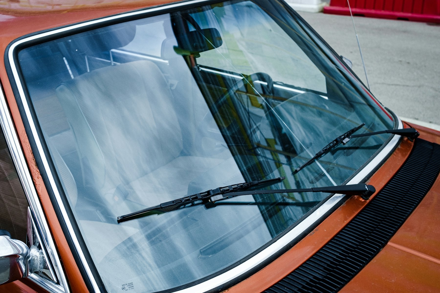 Clear windshield with wipers on an orange classic car
